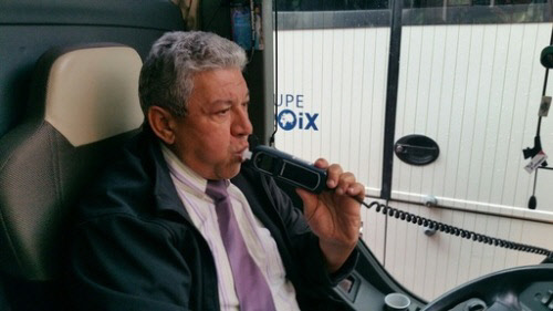 시동을 걸기 전 음주운전 시동잠금장치를 부는 파리의 관광버스 기사. 혈중알코올농도 0.02%를 넘으면 시동이 걸리지 않는다.  손해보험협회 제공